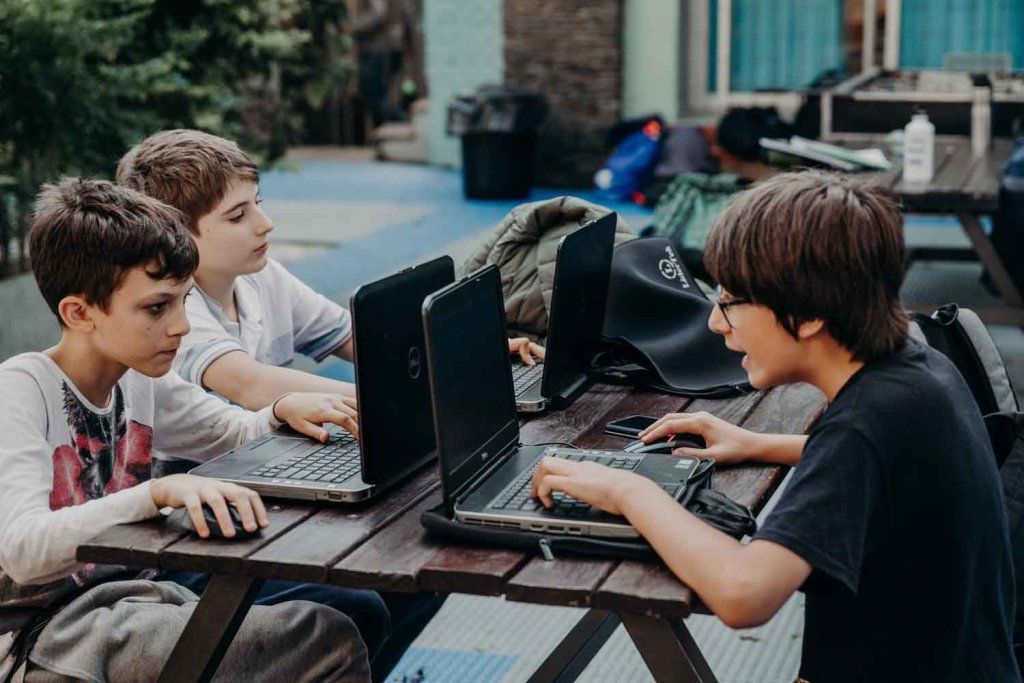 Adolescentes trabajando con computadoras