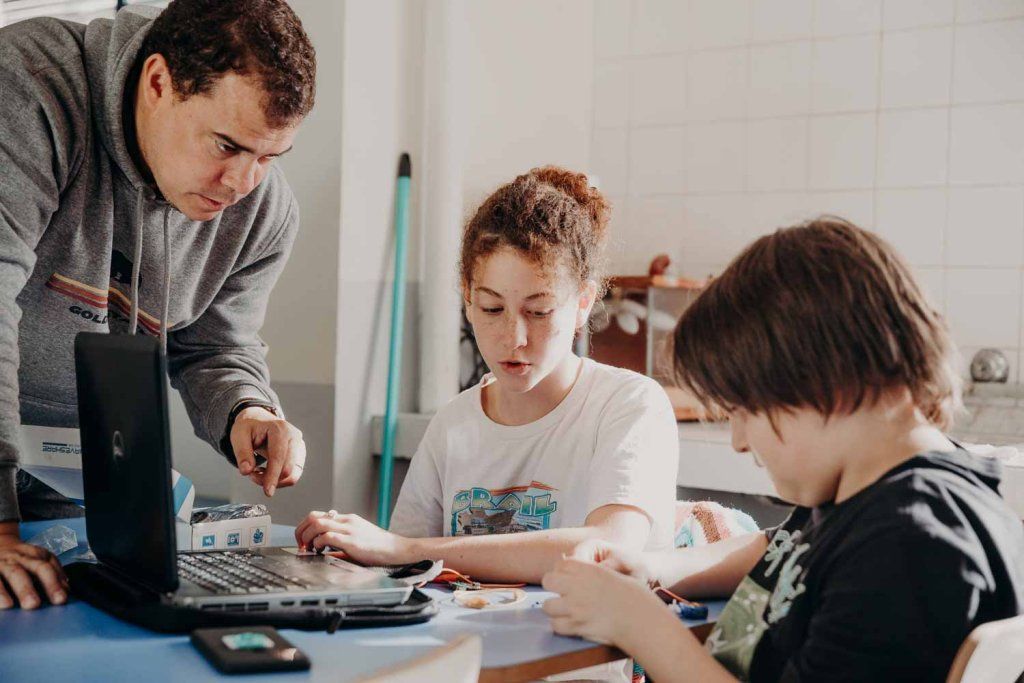 Adolescentes en taller de robótica con el docente
