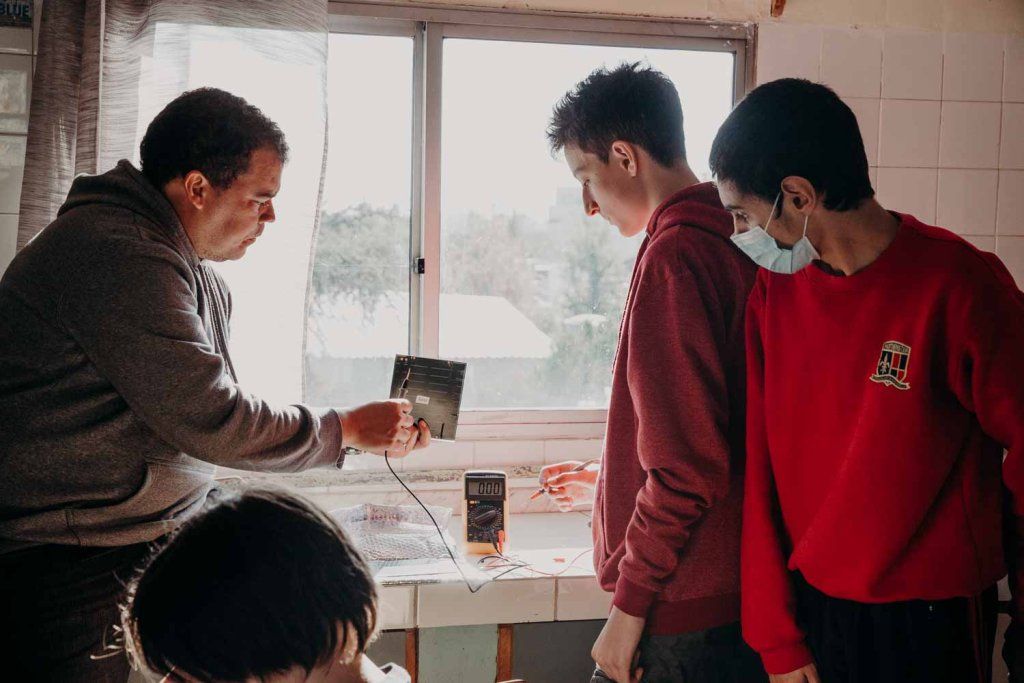 Adolescentes en taller de robótica con el docente