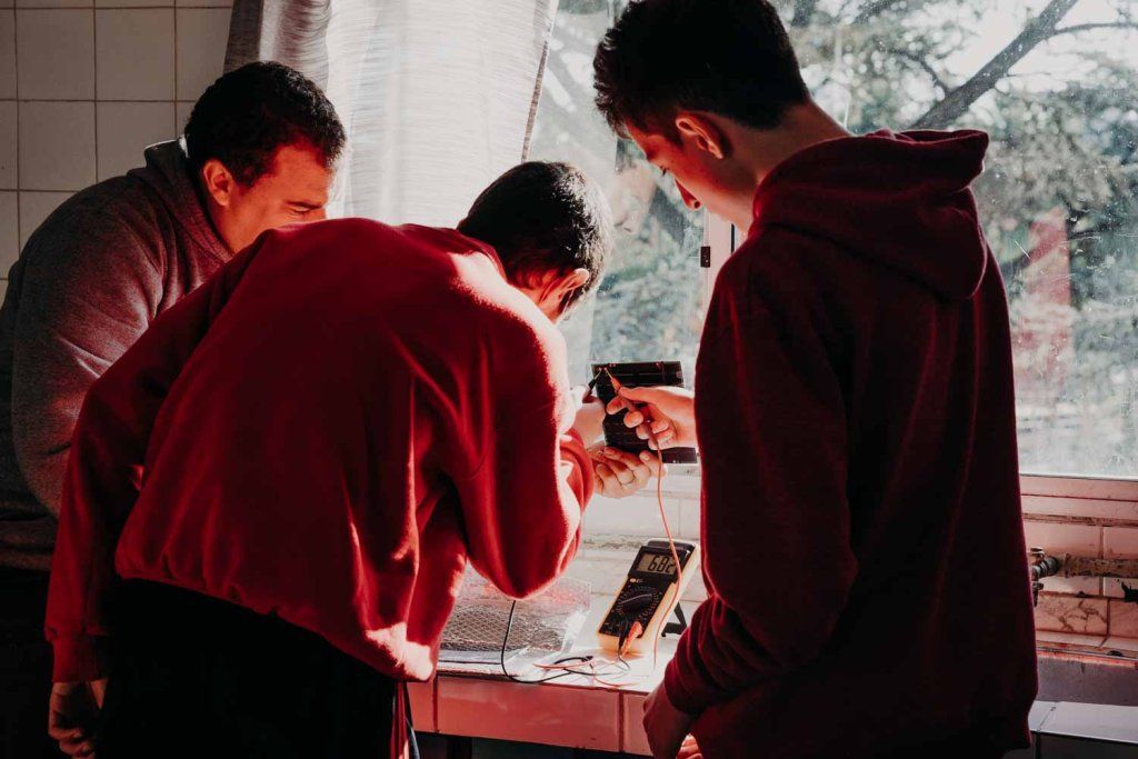 Adolescentes en taller de robótica con el docente