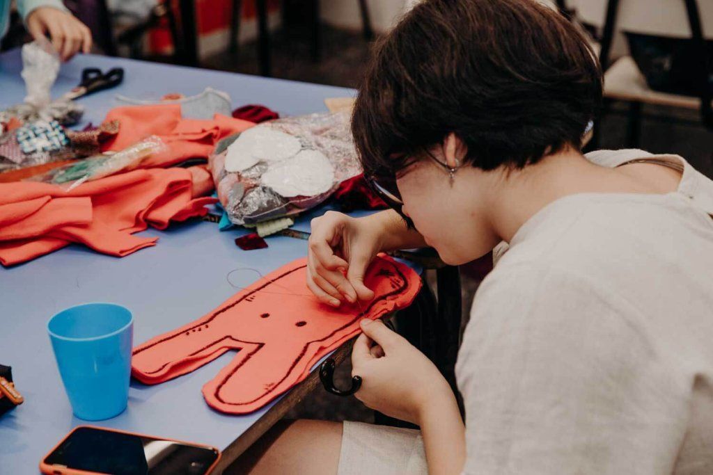 Adolescente cosiendo una pieza