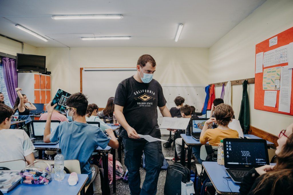 Adolescentes en salón de clase con computadoras personales
