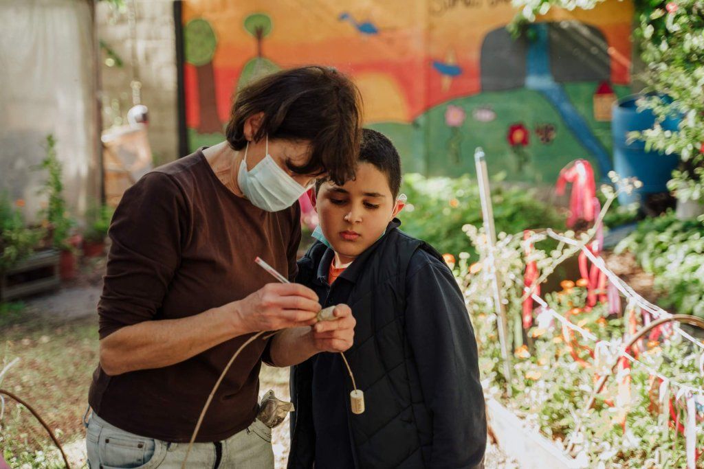 Niño trabajando en la huerta con la maestra