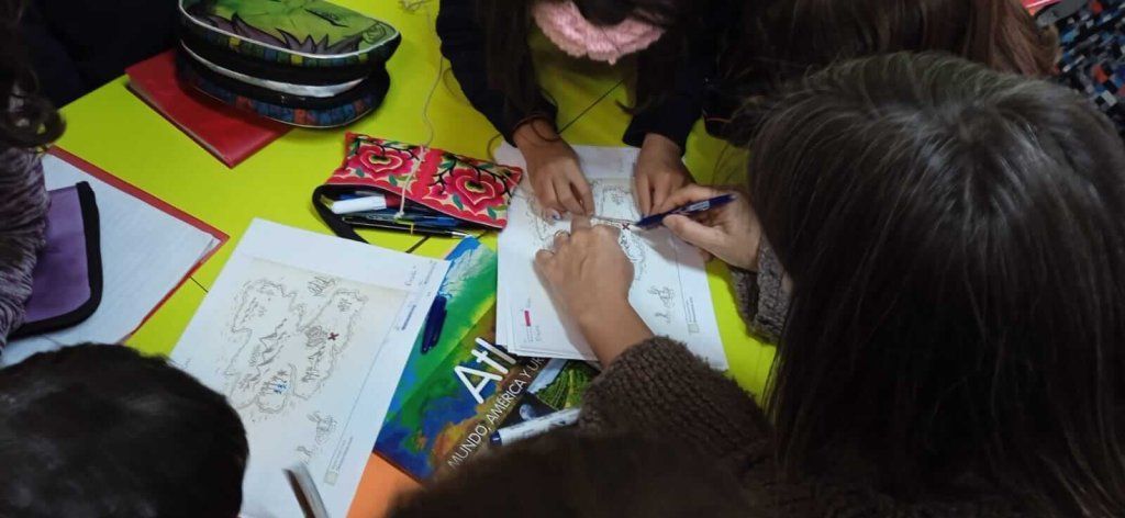 niños y niñas trabajando con un mapa