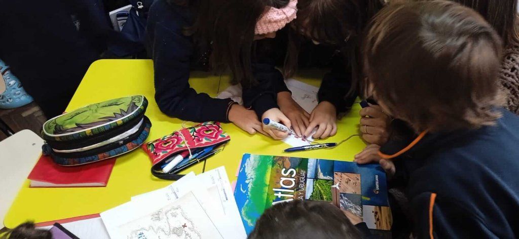 niños y niñas trabajando con un mapa