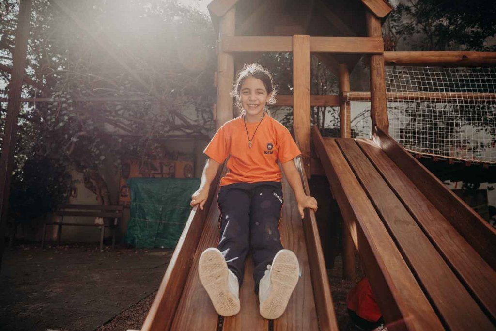 Niña deslizándose por un tobogán